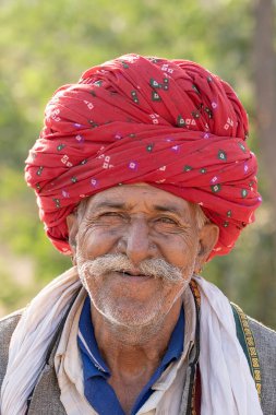 PUSHKAR, INDIA - 13 Kasım 2018: Hindistan 'ın kutsal şehri Pushkar, Rajasthan yakınlarındaki Pushkar Camel Mela sırasında çöldeki Hintli adam. Bu fuar dünyanın en büyük deve ticaret fuarı..