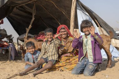 PUSHKAR, INDIA - 13 Kasım 2018: Hintli bir aile ve bir keçi ile birlikte çöldeki bir kulübede yaşıyor Pushkar Camel Mela, kutsal şehir Pushkar, Rajasthan, Hindistan