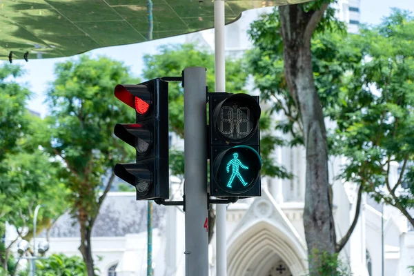 Traffic lights of a city with green figure of pedestrian on the street in Singapore, close up