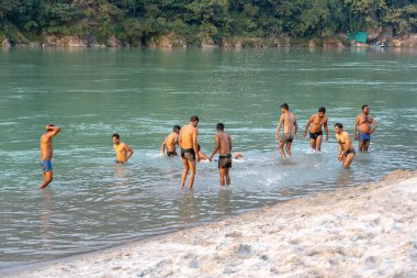 RISHIKESH, INDIA - Kasım 05, 2018: Hindistan 'ın Rishikesh kentindeki Ganj Nehri' nin kutsal sularında yüzen Hintli çocuklar.