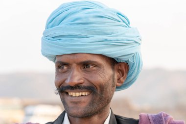 PUSHKAR, INDIA - 14 Kasım 2018: Hindistan 'ın kutsal şehri Pushkar, Rajasthan yakınlarındaki Pushkar Camel Mela sırasında çöldeki Hintli adam. Bu fuar dünyanın en büyük deve ticaret fuarı..