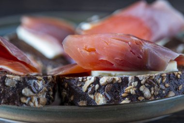 Taze somonlu sandviç, yakın çekim. Tuzlu somon, tereyağı ve tabakta siyah ekmek.