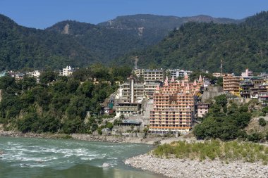 RISHIKESH, INDIA - 06, 2018: Rishikesh, Hindistan 'daki Ganj nehir seti, dağ ve hindu tapınağının güzel manzarası