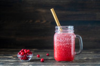 Bambu pipetli kızılcık ve inek meyveli buzlu içecek. Masadaki cam bardakta taze organik kırmızı smoothie, yakın çekim. Yaz meyvelerini tazeliyorum. Sağlıklı beslenme kavramı. Boşluğu kopyala