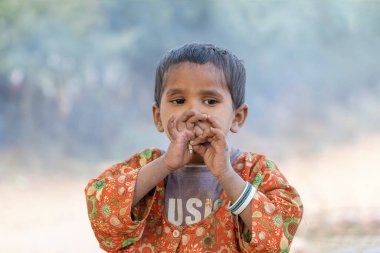 PUSHKAR, INDIA - 15 Kasım 2018: Hindistan 'ın Rajasthan kenti yakınlarında sigara içen Hintli genç kız. Çocukluktan itibaren, Hintli çocuklar kendilerine bırakılırlar ve hayatlarını kazanmaya başlarlar.