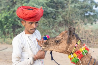 PUSHKAR, INDIA - 15 Kasım 2018: Hindistan 'ın kutsal şehri Pushkar, Rajasthan yakınlarındaki Pushkar Camel Mela sırasında çöldeki Hintli adam. Bu fuar dünyanın en büyük deve ticaret fuarı..