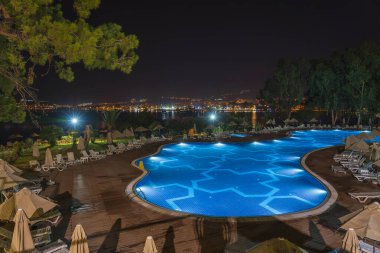 Didim, Türkiye - Eylül 02, 2019: Aydınlatılmış yüzme havuzu gece plajdaki turistik otelin yanında. Didim, Hindi. Tatil ve seyahat kavramı