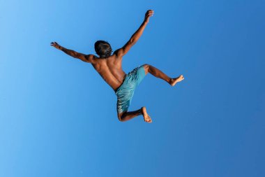 KOH PHANGAN, THAILAND - 18 Mayıs 2019: Mutlu Taylandlılar Tayland 'daki Koh Phangan adasının sahilindeki bir sıçrama tahtasından atlıyorlar