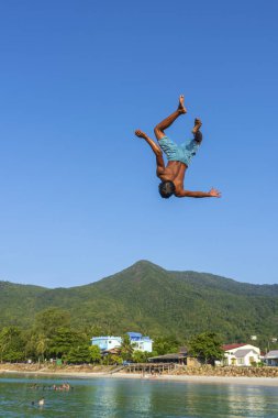 KOH PHANGAN, THAILAND - 18 Mayıs 2019: Mutlu Taylandlılar Tayland 'daki Koh Phangan adasının sahilindeki bir sıçrama tahtasından atlıyorlar