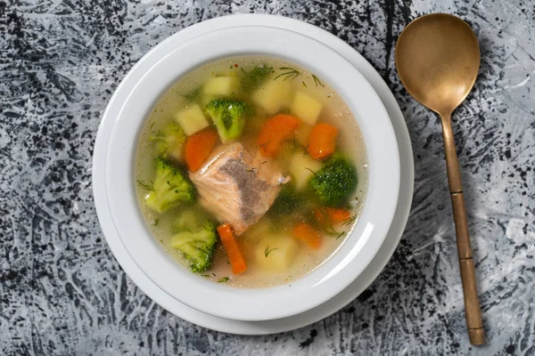 新鮮なサーモンの魚のスープ ニンジン ジャガイモ 玉ねぎを白いプレートに入れ 閉じます おいしいディナーは魚のスープとサーモンで構成されています トップ表示 — ストック写真