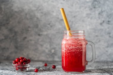 Bambu pipetli kızılcık ve inek meyveli buzlu içecek. Masadaki cam bardakta taze organik kırmızı smoothie, yakın çekim. Yaz meyvelerini tazeliyorum. Sağlıklı beslenme kavramı. Boşluğu kopyala
