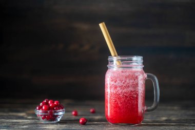 Bambu pipetli kızılcık ve inek meyveli buzlu içecek. Masadaki cam bardakta taze organik kırmızı smoothie, yakın çekim. Yaz meyvelerini tazeliyorum. Sağlıklı beslenme kavramı. Boşluğu kopyala