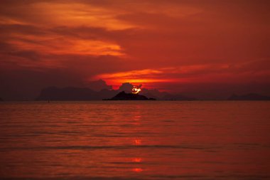 Güzel kırmızı renkli gün batımı ya da deniz manzarası üzerinde gün doğumu. Kırmızı romantik günbatımlı arka plan