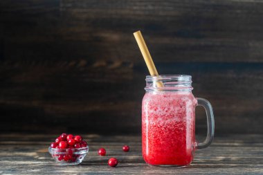 Bambu pipetli kızılcık ve inek meyveli buzlu içecek. Masadaki cam bardakta taze organik kırmızı smoothie, yakın çekim. Yaz meyvelerini tazeliyorum. Sağlıklı beslenme kavramı. Boşluğu kopyala