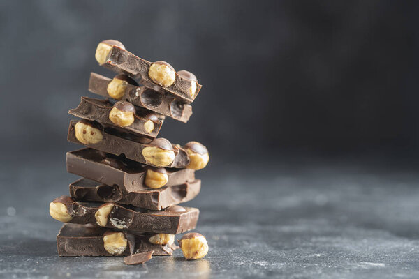 Pile chocolate with nuts on the gray background, close up