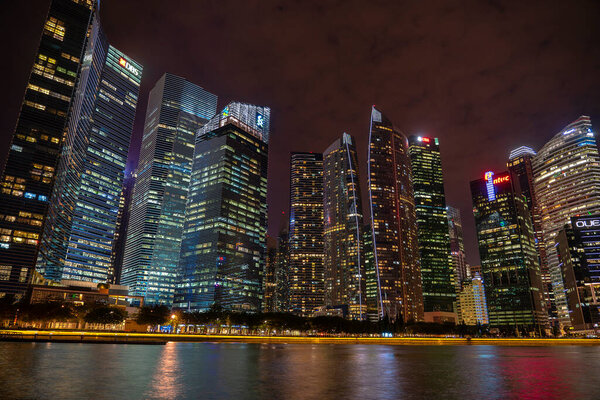 SINGAPORE CITY, SINGAPORE - MARCH 27, 2019: Singapore Skyline and view of skyscrapers on Marina Bay at night . Singapore cityscape of the financial district