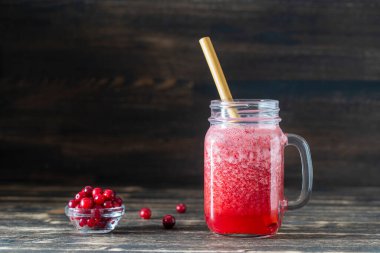 Bambu pipetli kızılcık ve inek meyveli buzlu içecek. Masadaki cam bardakta taze organik kırmızı smoothie, yakın çekim. Yaz meyvelerini tazeliyorum. Sağlıklı beslenme kavramı. Boşluğu kopyala