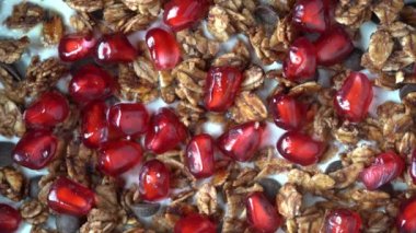 Yulaf ezmeli granola, kurutulmuş meyve, bal, kuru üzüm, çikolata parçacıkları, fındık ve yoğurtlu kırmızı nar tohumları, yakın çekim, üst manzara, dönüşümlü. Sağlıklı kahvaltı kavramı
