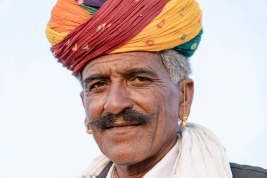 PUSHKAR, INDIA - 14 Kasım 2018: Hindistan 'ın kutsal şehri Pushkar, Rajasthan yakınlarındaki Pushkar Camel Mela sırasında çöldeki Hintli adam. Bu fuar dünyanın en büyük deve ticaret fuarı..