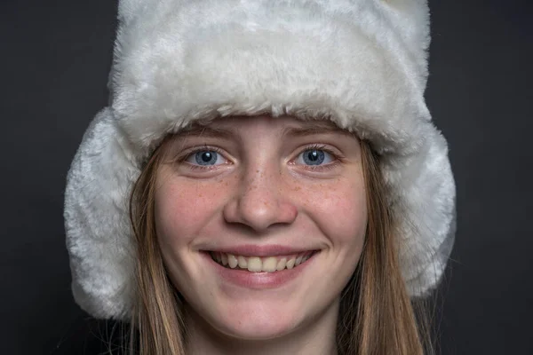 美しいですブロンド若いです女の子とともに冬の毛皮の帽子屋内で黒の背景 クローズアップ肖像画 — ストック写真