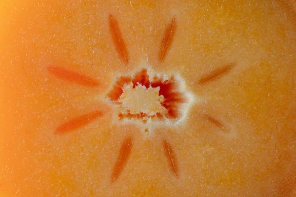 種子とパルプの食感で半分にカットオレンジ柿 柿のスライスの背景を閉じる 上のビュー マクロ — ストック写真