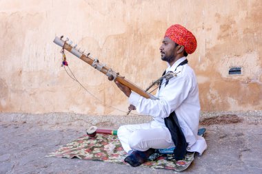 JAIPUR, INDIA - NOVEMBER 26, 2018: Hindistan 'ın eski kenti Jaipur, Rajasthan' daki Amber Fort yolunda turistler için Kamaycha adı verilen geleneksel müzik enstrümanında tanımlanamayan folk müzisyenleri çalıyor
