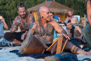 Koh Phangan, Tayland - 31 Ocak 2020: Sokak müzisyenleri gün batımında Tayland 'ın Koh Phangan adasında deniz kenarında turistler için davul çalıyorlar