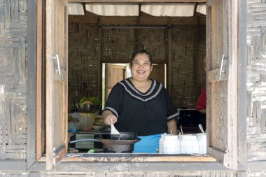 KOH PHANGAN, THAILAND - Şubat 05, 2019 Taylandlı kadın Koh Phangan, Tayland 'da bir sahil kafesinde yemek hazırlıyor. Sokak Tayland yemeği, yakın çekim.