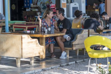 Bodrum, Türkiye - Eylül 2019: Bir erkek ve bir kadın Bodrum, Türkiye 'de bir sahil kafede eğleniyor ve gülüyorlar