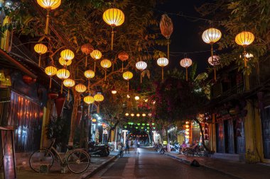 Hoi An, Vietnam - 15 Mart 2020 Hoi An kasabasında nehir kenarındaki renkli sokak ve açık hava kafesi. Hoi An, Vietnam 'ın ortasında Da Nang yakınlarında bir şehirdir ve nehir kıyısındaki iyi korunmuş eski kasabasıyla ünlüdür.