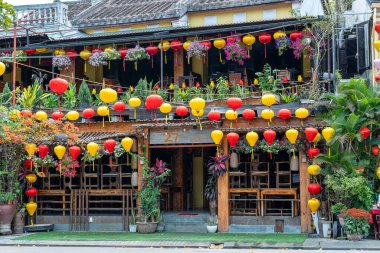 Hoi An, Vietnam - 15 Mart 2020 Hoi An nehrinin yanında renkli kırmızı ve sarı lambalı sokak restoranı. Hoi An, Vietnam 'ın ortasında Danang yakınlarında bir şehirdir ve iyi korunmuş eski kasabasıyla ünlüdür.