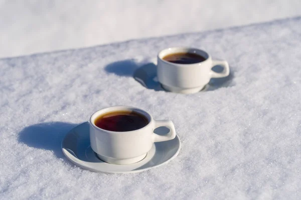 白色两杯热咖啡 在雪床和白色的背景 圣诞节及冬日早上的概念 — 图库照片