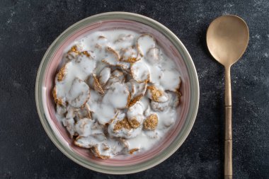 Tam tahıllı gevrek ve yoğurt tabağı, yakın çekim, üst manzara. Sağlıklı kahvaltı, bir kâse dolusu müsli.