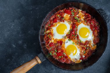 Shakshuka, domatesli sahanda yumurta, soğan, kırmızı biber ve dökme demir tavada baharat, kapat.
