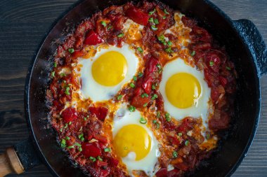 Shakshuka, domatesli sahanda yumurta, soğan, kırmızı biber ve dökme demir tavada baharat, kapat.