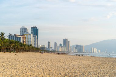 Danang, Vietnam - 20 Haziran 2020: Vietnamlılar sabah Da nang, Vietnam 'da güneş doğmadan önce plajda dinlenip denizde yüzüyorlar.