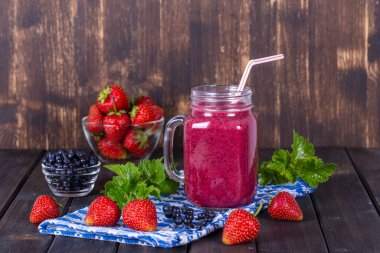 Sağlıklı beslenme, beslenme, diyet ve vejetaryen konsepti - Mason kavanozunda çilek, yabanmersini ve muzdan yapılan smoothie, kapat