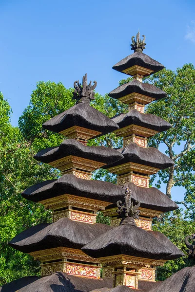 The architecture of the Hindu temple on the island of Bali in Ubud, Indonesia, Asia. High thatched roof tower and blue sky