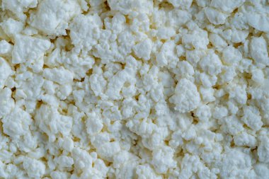 Süzme peynir arka plan, üst manzara. Süt ürünlerinin beyaz taneli dokusu, süzme peynir, yakın çekim. Süt ürünü konsepti