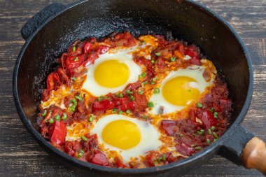 Shakshuka, domatesli sahanda yumurta, soğan, kırmızı biber ve dökme demir tavada baharat, kapat.