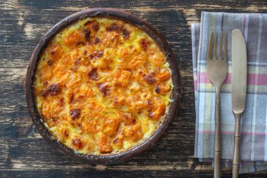 Süt soslu fırında sarı balkabağı, ahşap masadaki bir tabakta bal ve yumurta, üst manzara. Vejetaryen yemeği, Ukrayna, yakın çekim.