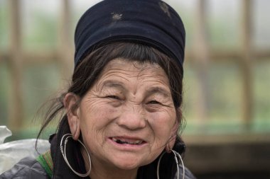 Sapa, Vietnam - Mart 06, 2020: Geleneksel elbiseli Hmong etnik kadın, Sapa, Kuzey Vietnam 'daki dağ köyünde el sanatları satan turistleri bekliyor