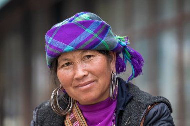 Sapa, Vietnam - Mart 02, 2020: Geleneksel elbiseli Hmong etnik kadın, Sapa, Kuzey Vietnam 'daki dağ köyünde el sanatları satan turistleri bekliyor