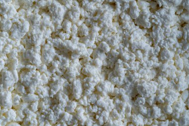 Süzme peynir arka plan, üst manzara. Süt ürünlerinin beyaz taneli dokusu, süzme peynir, yakın çekim. Süt ürünü konsepti