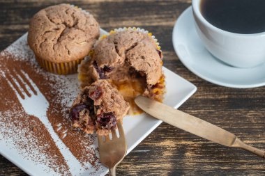 Tatlı vişneli kek ve beyaz kupa, ahşap zemin üzerinde çay, yakın çekim