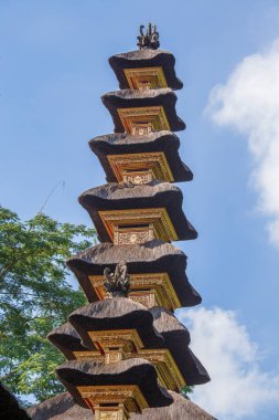 Ubud, Endonezya, Asya 'daki Bali adasındaki Hindu tapınağının mimarisi. Yüksek sazdan çatı kulesi ve mavi gökyüzü