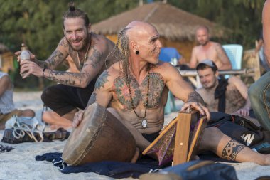 Koh Phangan, Tayland - 31 Ocak 2020: Sokak müzisyenleri gün batımında Tayland 'ın Koh Phangan adasında deniz kenarında turistler için davul çalıyorlar