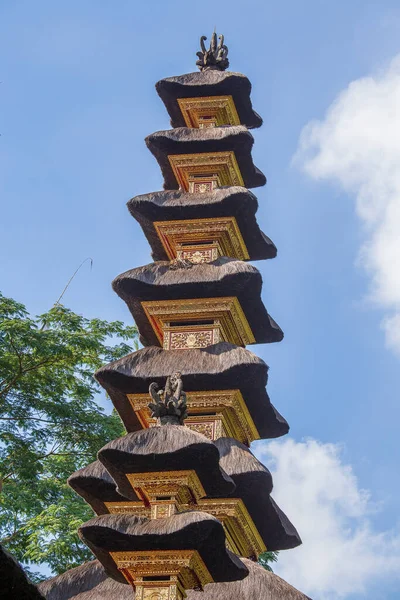 The architecture of the Hindu temple on the island of Bali in Ubud, Indonesia, Asia. High thatched roof tower and blue sky