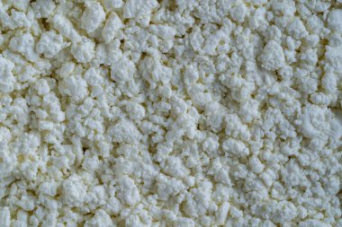 Süzme peynir arka plan, üst manzara. Süt ürünlerinin beyaz taneli dokusu, süzme peynir, yakın çekim. Süt ürünü konsepti