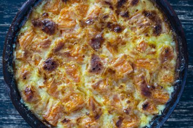 Süt soslu fırında sarı balkabağı. Tahta masadaki bir tabakta bal ve yumurta. Vejetaryen yemeği, Ukrayna, yakın çekim.